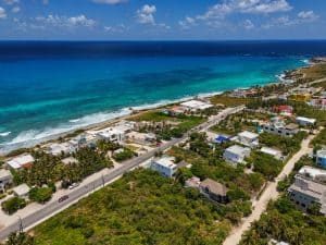 Stunning coastal view of beachfront homes and lush greenery in a tropical paradise. Isla Mujeres Mexico Property