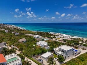 Stunning coastal view of beachfront homes and lush greenery in a tropical paradise. Isla Mujeres Mexico Property