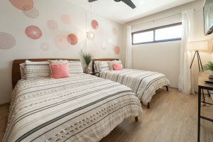 Bright modern bedroom with two beds, stylish decor, and natural light, ideal for comfortable living. Isla Mujeres Mexico Property