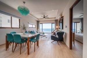Modern beachfront living room with ocean view, stylish furniture, and bright natural light.