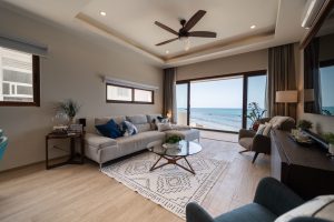 Bright living room with ocean view, modern furniture, and natural light in a beachfront property.