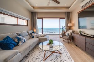 Relaxing living room with ocean view, modern furniture, and natural light in a beachfront property.