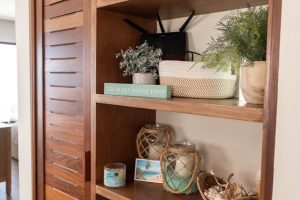 Interior shelf with decorative plants and jars in a cozy home setting.
