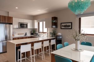 Modern kitchen and dining area with stylish decor, natural light, and contemporary furniture in a lu.