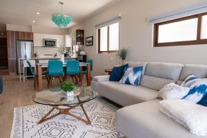 Modern living room with open kitchen, large windows, and stylish decor in a contemporary home.