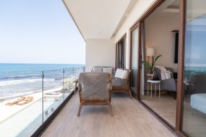 Stunning beachfront balcony with ocean views and modern furniture for relaxing stays.