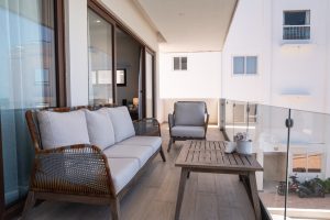 Modern beachfront balcony with outdoor seating and scenic views in Cancun.