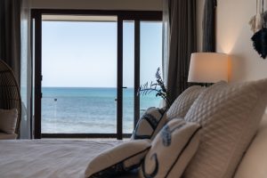 Bright ocean view from a luxurious bedroom with sliding glass doors at Mundaca Real Estate.