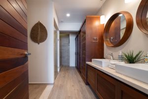 Modern bathroom with wooden accents, double sinks, and stylish mirrors in a contemporary home.