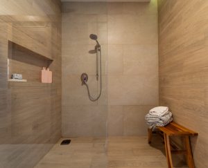 Modern walk-in shower with beige tiles and minimalist design in a luxury bathroom.