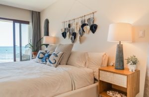 Bright bedroom with ocean view, cozy decor, and stylish furnishings at Mundaca Real Estate. Perfect.