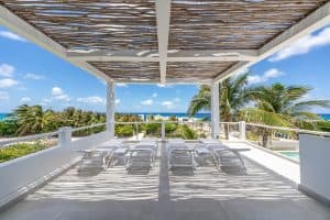 Relaxing beachfront terrace with lounge chairs and ocean view in Mundaca Real Estate property. Isla Mujeres Mexico Property