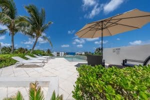 Relaxing poolside area with lounge chairs and tropical greenery in a luxury property in Mexico. Isla Mujeres Mexico Property