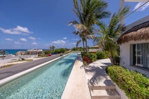 Relaxing beachfront pool with palm trees at Mundaca Real Estate property in Mexico. Isla Mujeres Mexico Property