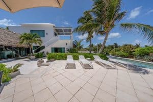 Luxurious beachfront villa with pool, palm trees, and modern architecture in Mexico. Isla Mujeres Mexico Property
