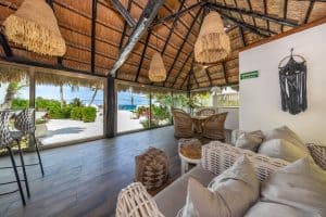 Relaxing tropical lounge with ocean view, wicker furniture, and thatched roof at Mundaca Real Estate. Isla Mujeres Mexico Property