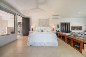 Spacious bedroom with white bedding, modern decor, and natural light in a luxury property. Isla Mujeres Mexico Property