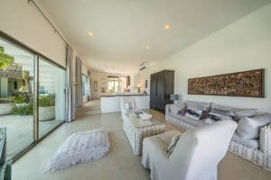 Modern living room with bright natural light, white furniture, and tropical decor in a beachfront pr. Isla Mujeres Mexico Property