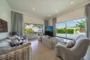 Modern living room with large windows, tropical views, and comfortable white furniture in a beachfro. Isla Mujeres Mexico Property