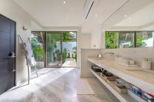 Modern bathroom with large glass doors and natural light in a luxury home. Isla Mujeres Mexico Property