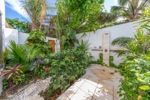 Tropical garden with lush greenery and outdoor shower area in a private backyard. Isla Mujeres Mexico Property