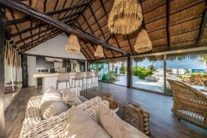 Relaxing tropical beachfront living space with open-plan kitchen and stunning ocean views. Isla Mujeres Mexico Property