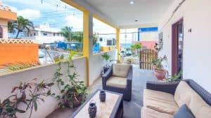 A cozy outdoor patio with comfortable seating and lush plants in a residential area. Isla Mujeres Mexico Property