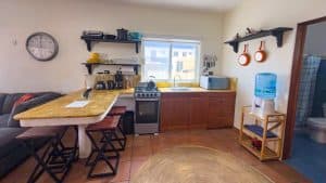 A comfortable kitchen with wooden cabinets, modern appliances, and a water dispenser, ideal for home. Isla Mujeres Mexico Property
