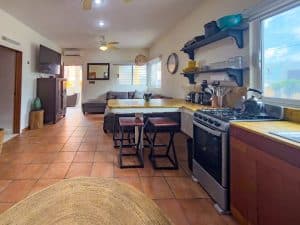 Interior view of a cozy kitchen and living area in a Mexican home with tiled floors and modern appli. Isla Mujeres Mexico Property
