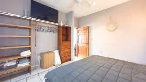 Modern bedroom with wooden closet, shelves, and natural light in a residential property. Isla Mujeres Mexico Property