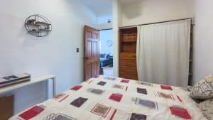 Cozy bedroom with wooden accents and a colorful bedspread, ideal for relaxing in a charming home. Isla Mujeres Mexico Property
