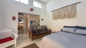 Spacious living room with high windows and cozy seating, ideal for relaxing in a beachfront property. Isla Mujeres Mexico Property