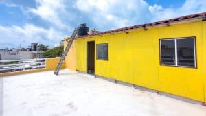 Bright yellow rooftop terrace with city views and solar water heater, ideal for outdoor living and r. Isla Mujeres Mexico Property