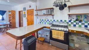 Modern kitchen with stove, utensils, and colorful backsplash in a residential property. Isla Mujeres Mexico Property
