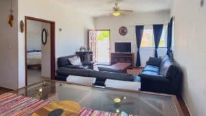 Modern living room with black sofas, TV, and large windows in a residential property. Isla Mujeres Mexico Property