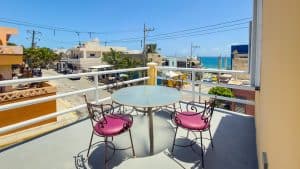 Bright balcony with ocean view, outdoor seating, and vibrant surroundings in a coastal neighborhood. Isla Mujeres Mexico Property