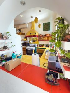 Bright, colorful kitchen with modern appliances and lush green plants, ideal for cozy home living in. Isla Mujeres Mexico Property