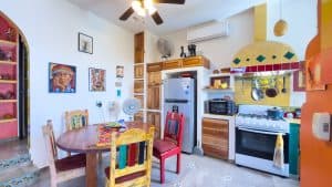 Cozy kitchen with colorful furniture and modern appliances in a vibrant home setting. Isla Mujeres Mexico Property