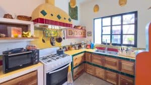 Colorful Mexican-style kitchen with vibrant tiles and traditional decor, bright natural light. Isla Mujeres Mexico Property