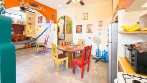 Bright and colorful living room with playful decor, dining area, and children's play space in a vibr. Isla Mujeres Mexico Property
