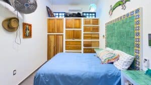 Relaxing bedroom with colorful decor and wooden furniture in a tropical home. Isla Mujeres Mexico Property