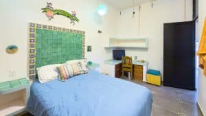 A comfortable bedroom with colorful decor and modern furniture in a property listed by Mundaca Real. Isla Mujeres Mexico Property