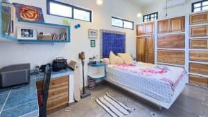 Modern bedroom with wooden furniture, colorful decor, and natural light in a contemporary home. Isla Mujeres Mexico Property