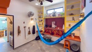Relaxed interior with hammock, colorful shelves, and musical instruments in a cozy home setting. Isla Mujeres Mexico Property