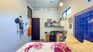 Modern bedroom with colorful decor and blue tiled wall, ideal for real estate listings in Mexico. Isla Mujeres Mexico Property