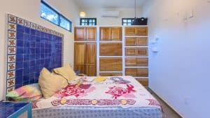 Bright bedroom with wooden storage and colorful tiled wall, ideal for comfortable living in Mexico. Isla Mujeres Mexico Property