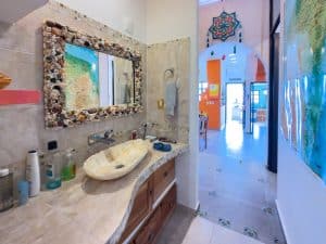 Beautiful bathroom with natural stone sink and ocean-inspired decor in Mundaca Real Estate property. Isla Mujeres Mexico Property