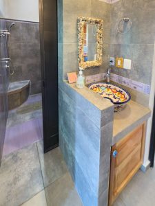 Modern bathroom sink with colorful mosaic design and decorative mirror in a contemporary space. Isla Mujeres Mexico Property