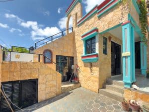 Modern Mexican-style house with colorful accents and stone facade, located in a scenic area. Isla Mujeres Mexico Property