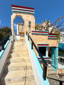 Brightly colored outdoor staircase leading to a modern house with vibrant accents and stone details. Isla Mujeres Mexico Property